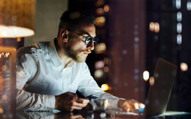 IT professional using laptop in office at night