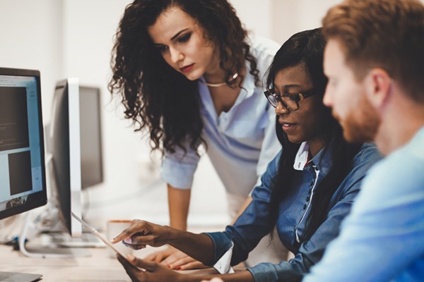 Team collaborating around desktop computer