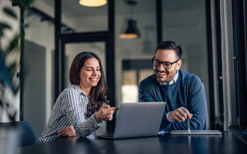 Two users collaborating on laptop