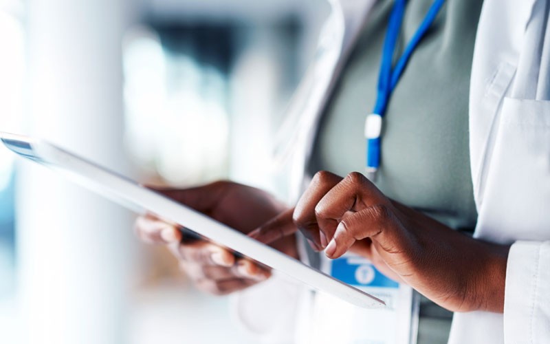 Close up of hospital employee using tablet device