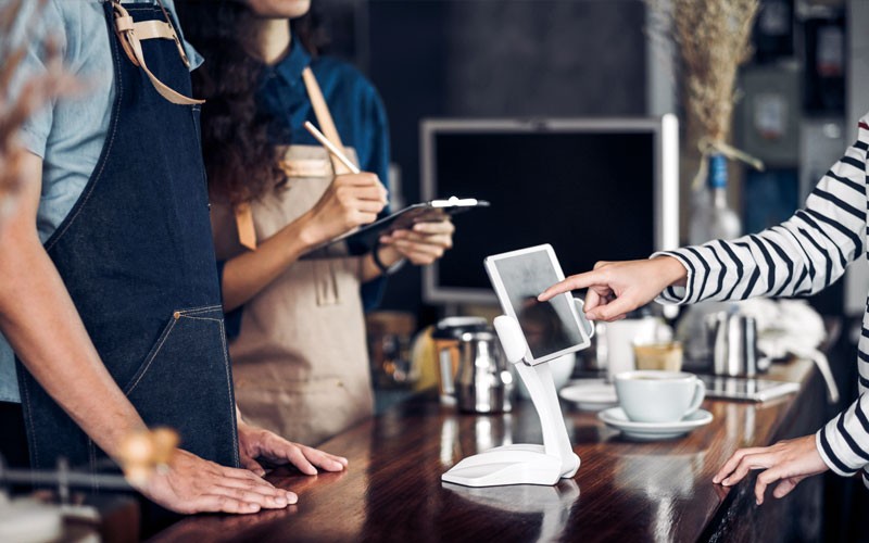 Cafe customer using touch screen for purchase