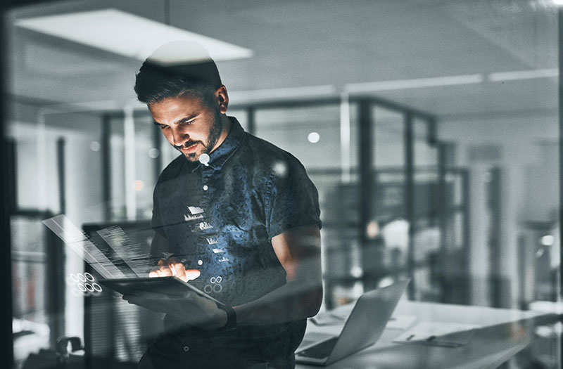 Man working on tablet with software application graphic overlay